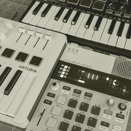 Monochrome photo of two midi keyboards and a groovebox.