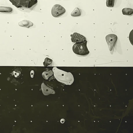 Monochrome photo of climbing holds on a climbing wall.